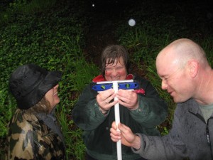 Ellen Osten, Becca Schuler and Errin Odell demonstrate the use of a level for simple surveying.